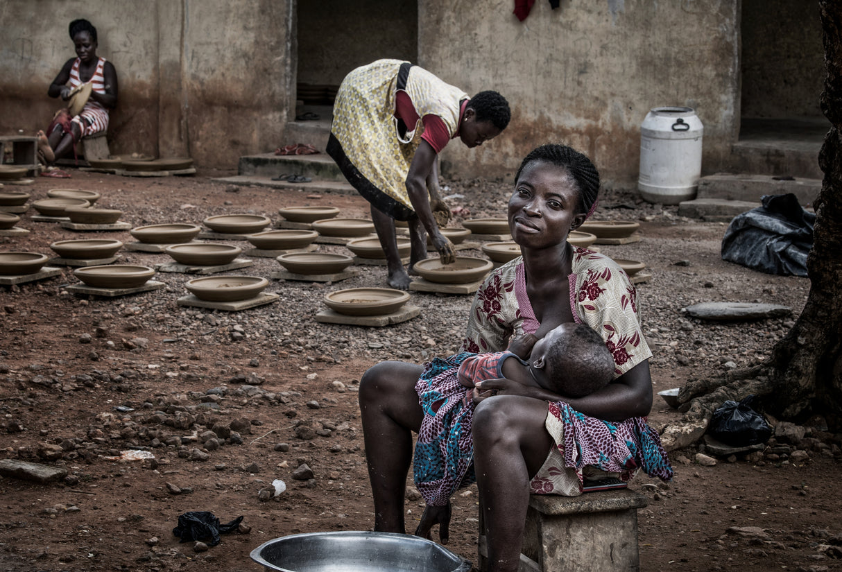 A break in the making of pottery to breastfeed her child - Ghana Poster och Canvastavla