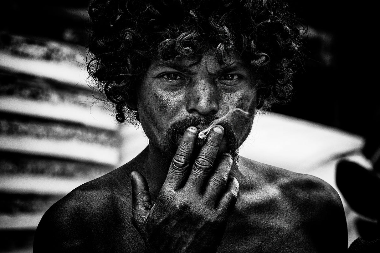 A homeless man smoking in the streets of Delhi. Poster och Canvastavla