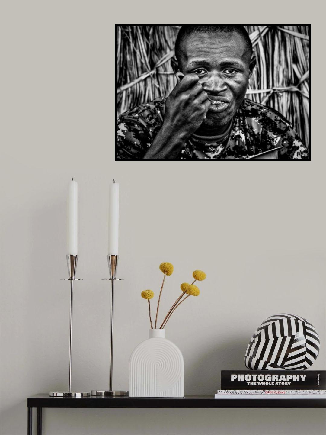 El Molo ethnic man eating at the entrance of his home. Poster och Canvastavla
