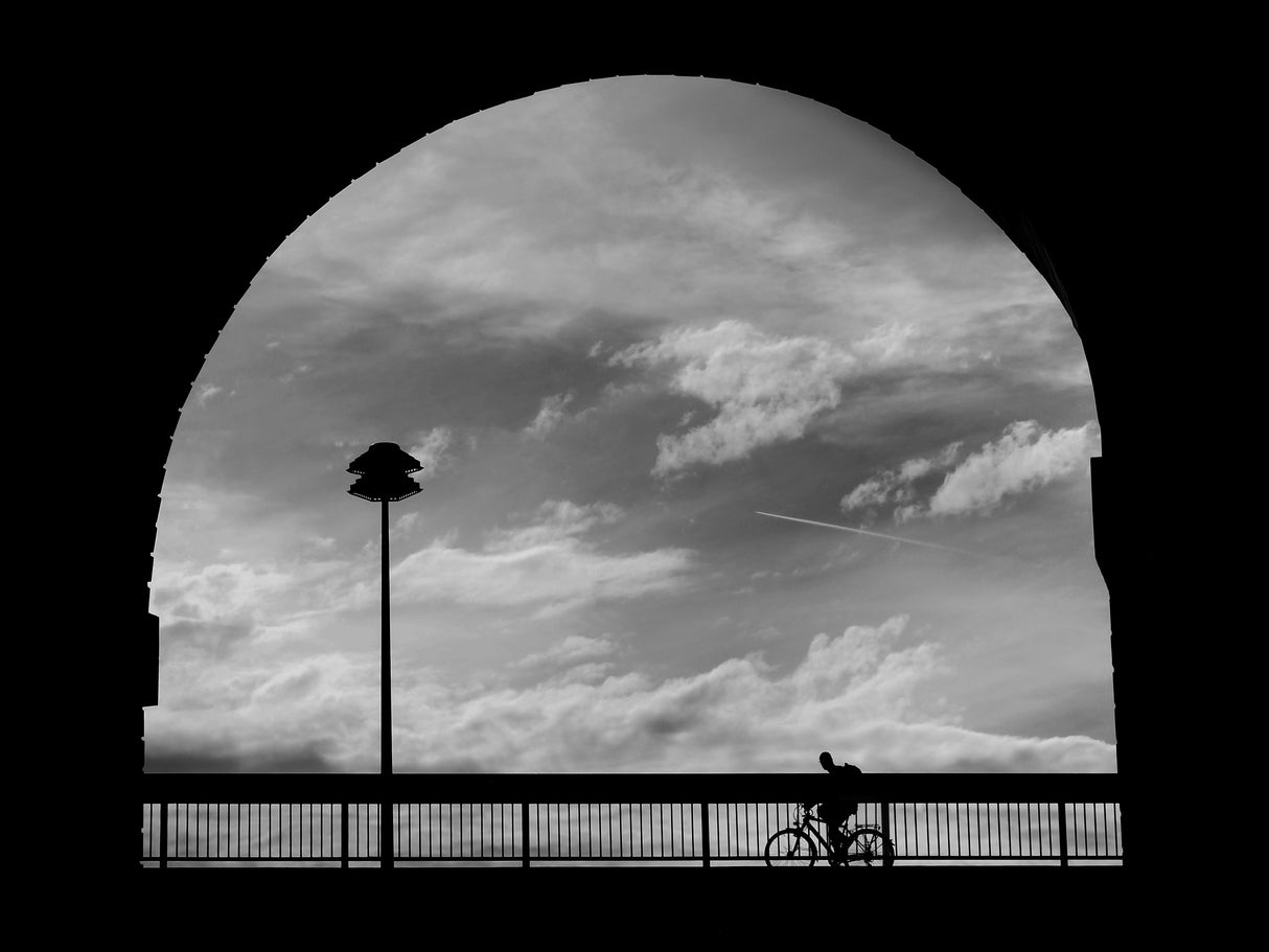 Cyclist, clouds and street lamp in the arch Poster och Canvastavla