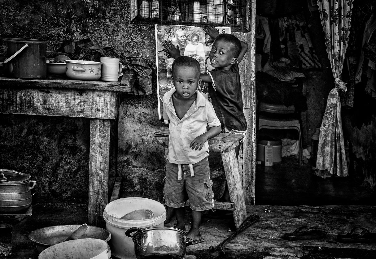 Two children sticking up a poster in the streets of Accra -Ghana Poster och Canvastavla