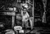 Two children sticking up a poster in the streets of Accra -Ghana Poster och Canvastavla