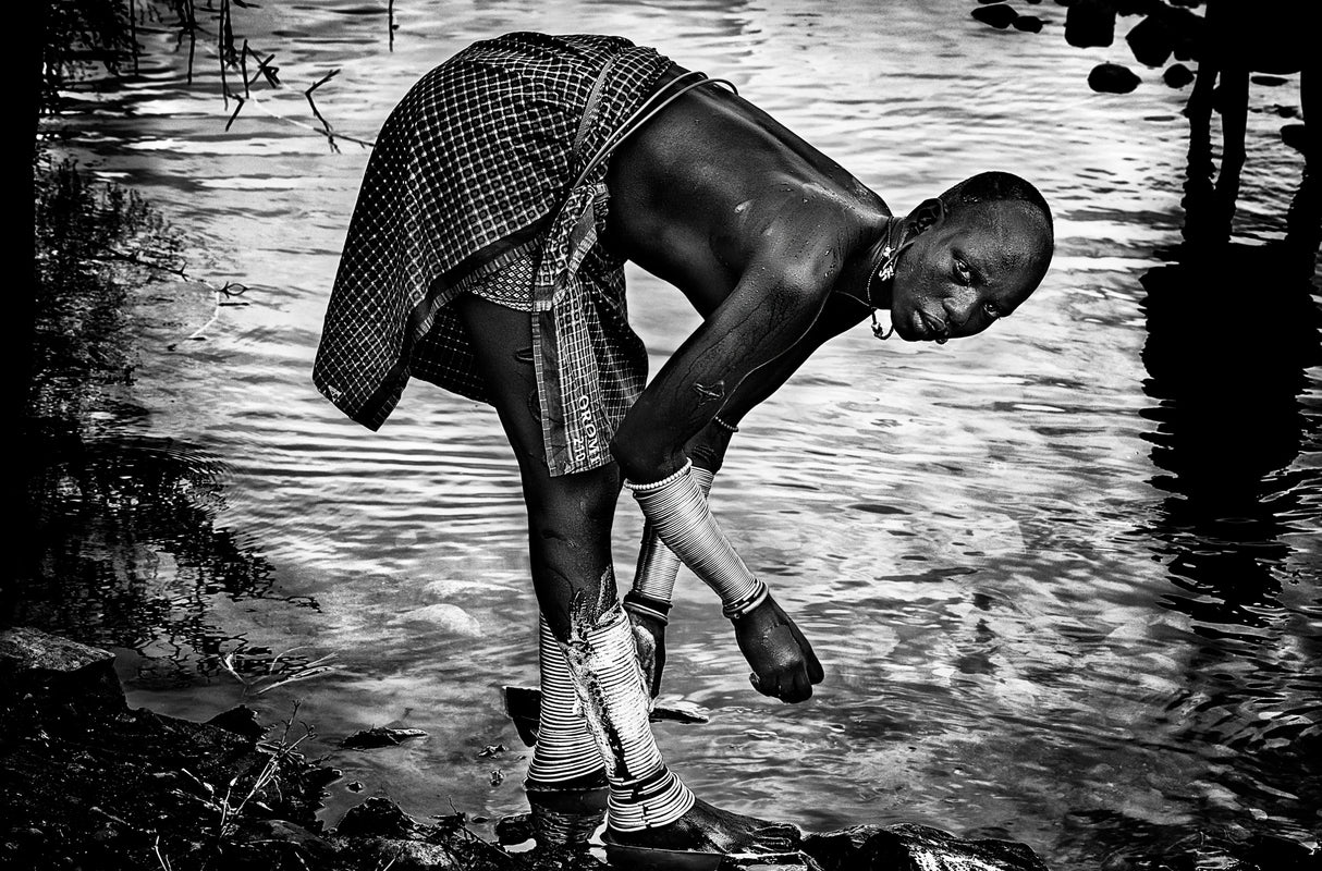 Surma tribe woman washing up her jewelry - Ethiopia Poster och Canvastavla