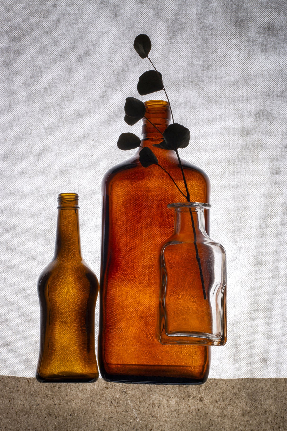 Still life with colored bottles and a dried twig Poster och Canvastavla