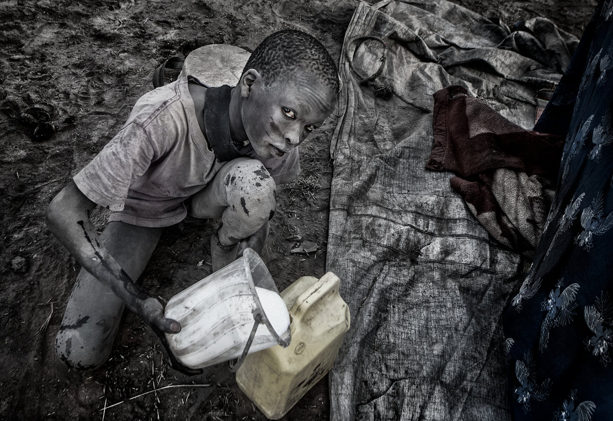 Mundari child passing the freshly milked milk to another container. Poster och Canvastavla