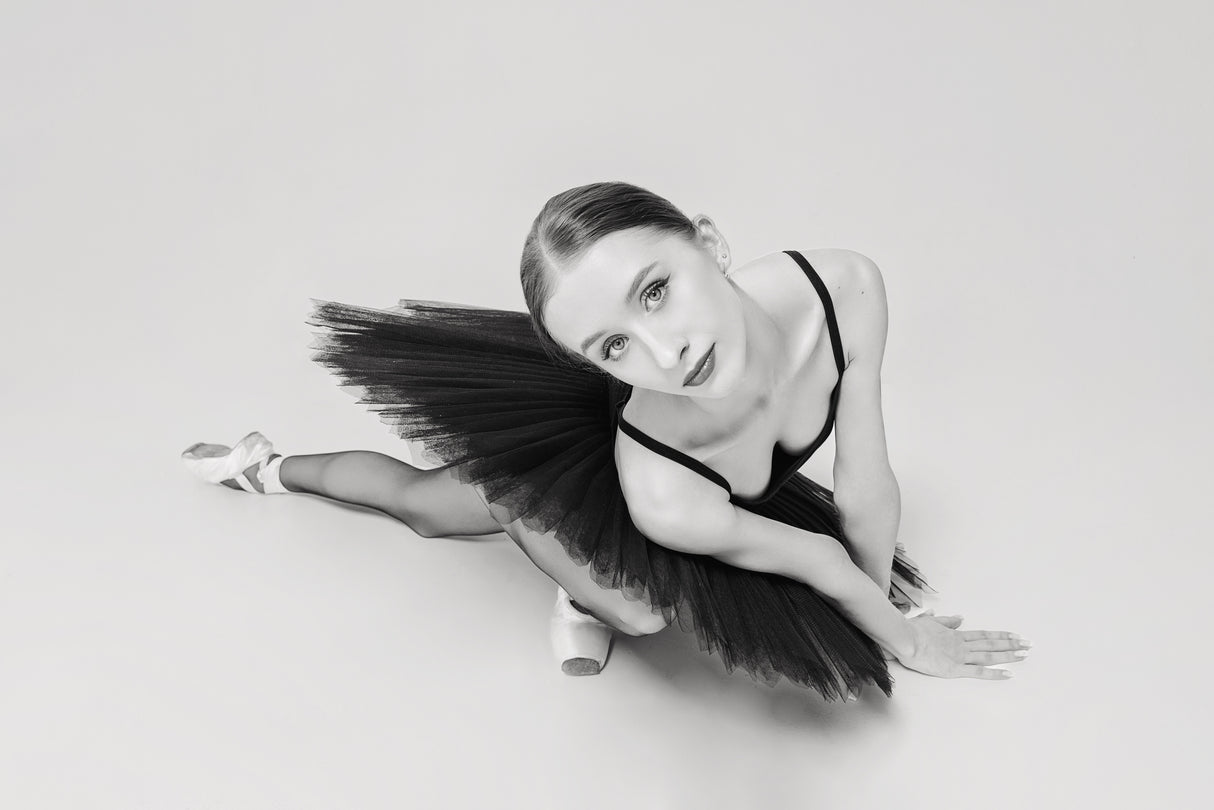 portrait of a ballerina in a black tutu lying on the floor leaning on her hands top view Poster och Canvastavla