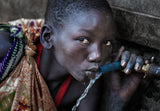 Surmi tribe girl drinking water from a tap - Ethiopia Poster och Canvastavla