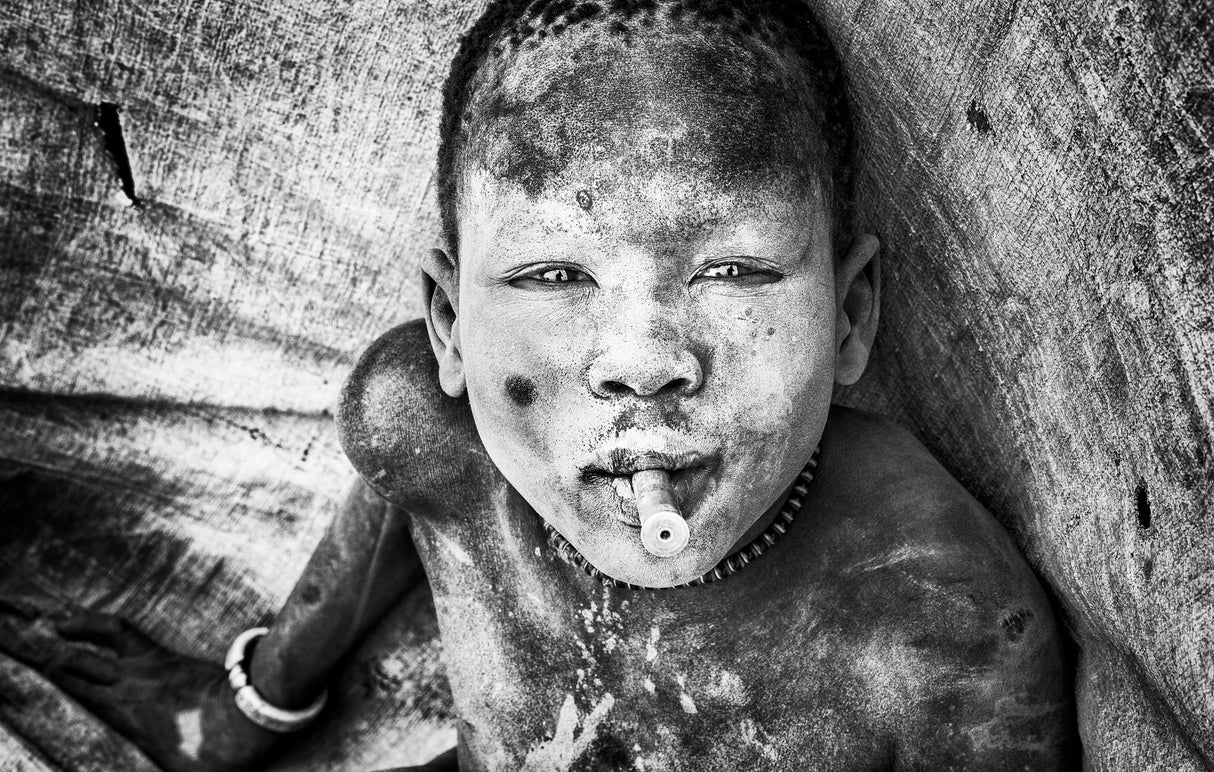 Mundari child playing with a bullet casing - South Sudan Poster och Canvastavla