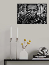 El Molo ethnic man eating at the entrance of his home. Poster och Canvastavla