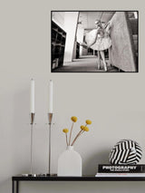 ballerina on pointe shoes in the library reads a book holding it up Poster och Canvastavla